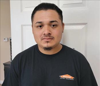 Man in black shirt, white door behind