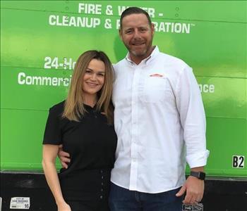 Woman and man in front of green truck