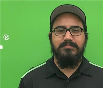 Man in black shirt in front of green background