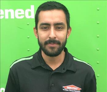 Man in black shirt in front of green background