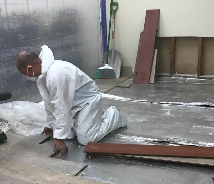 Technician removing floorboards