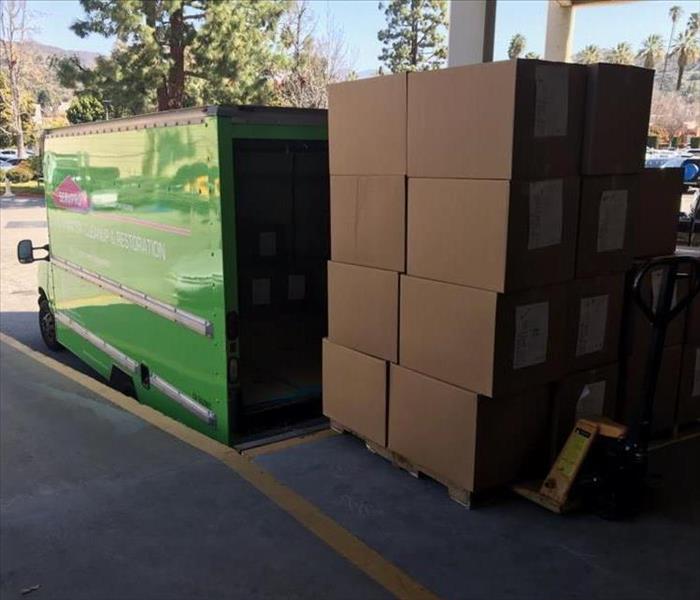 Brown boxes loaded into a green truck